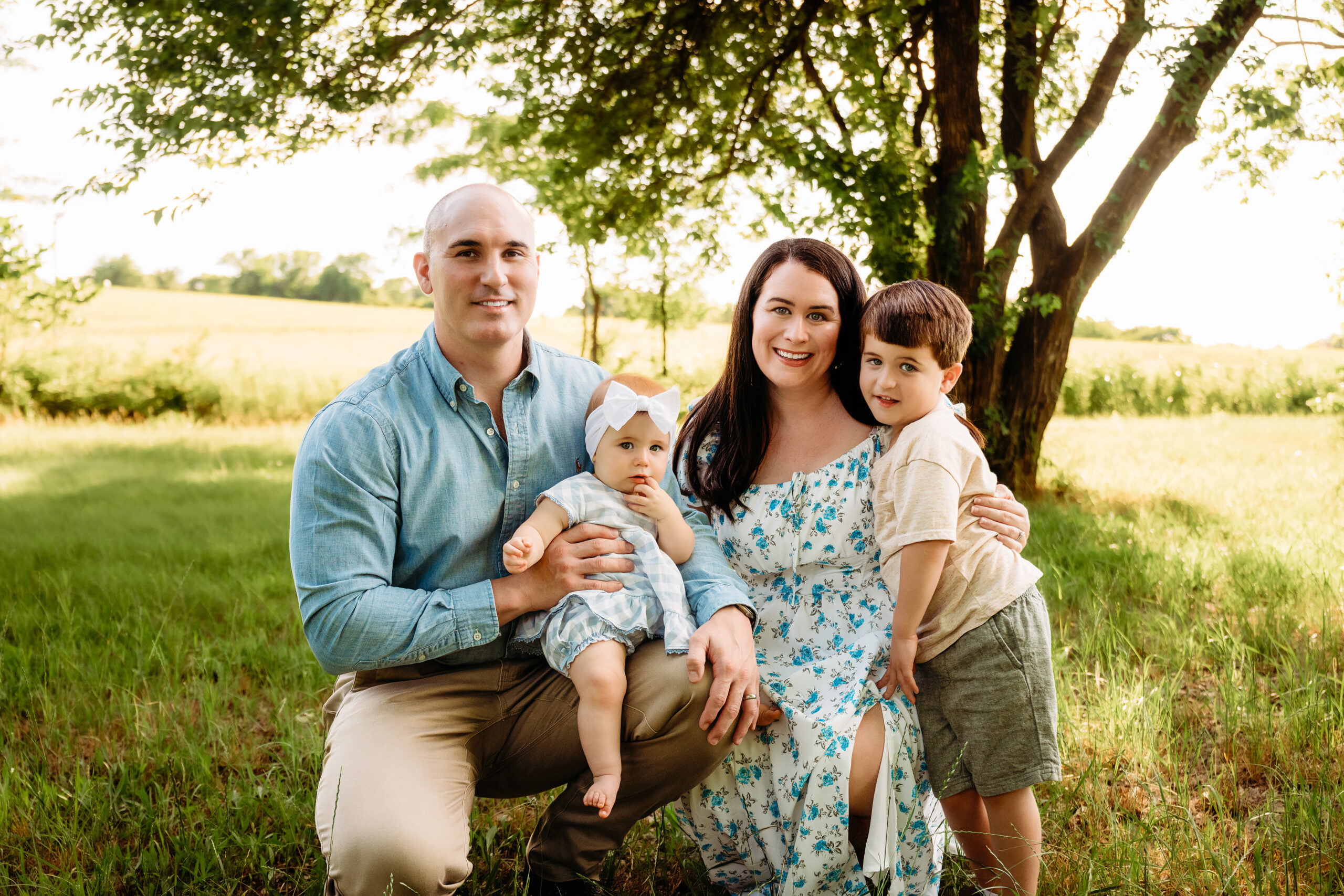 family of 4 taking pictures during golden light. Everyone is smiling and looking at the camera while shelly voss captures their moment