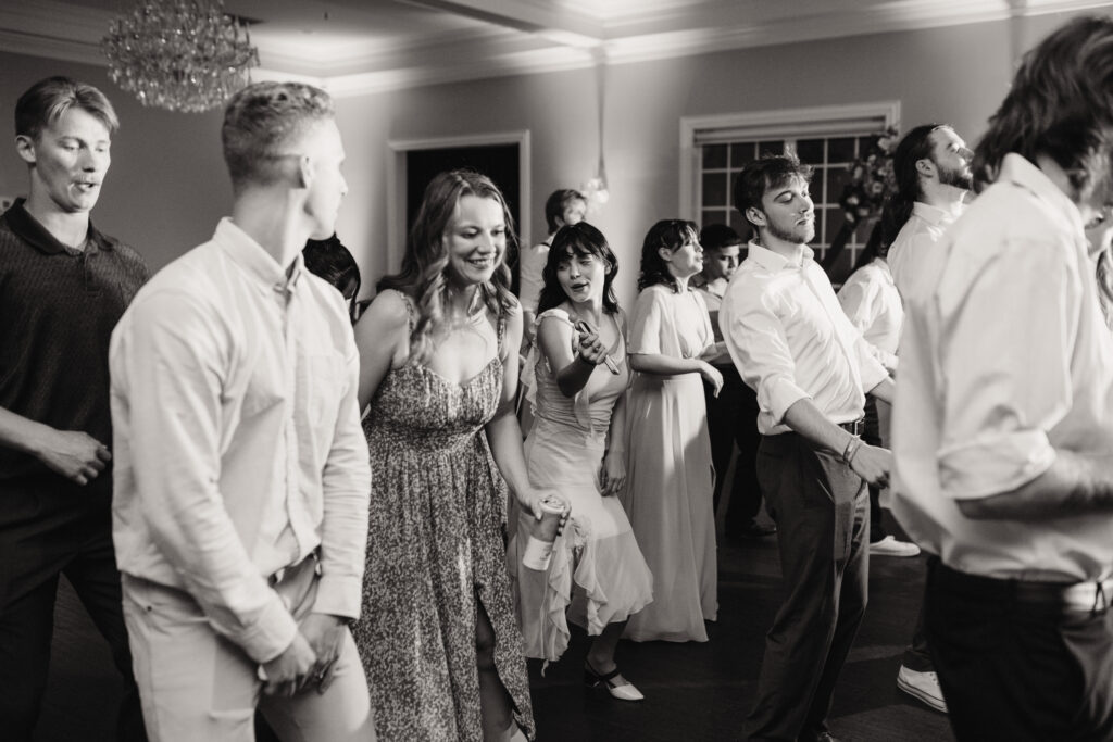 a black and white photo of guest dancing the night away at the milestone mansion in denton, texas.