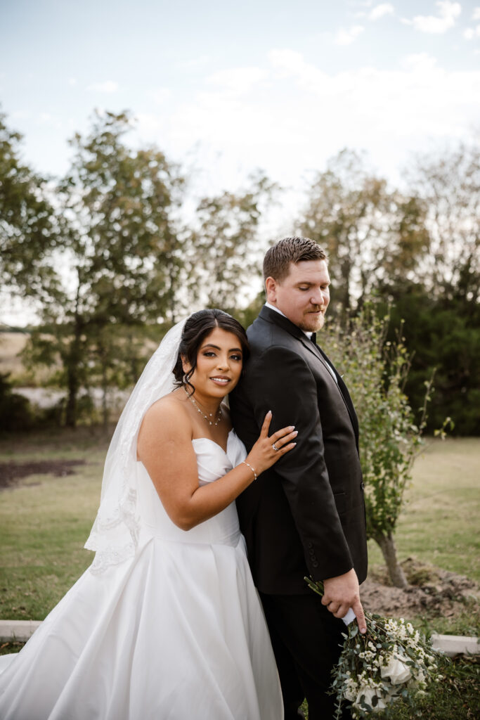 the bride rests her head on the grooms arm during a golden hour portrait outside their venue.

