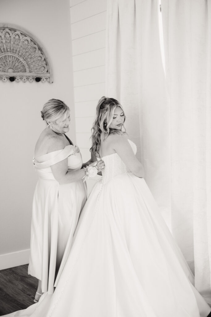 bride getting into dress in bridal suite