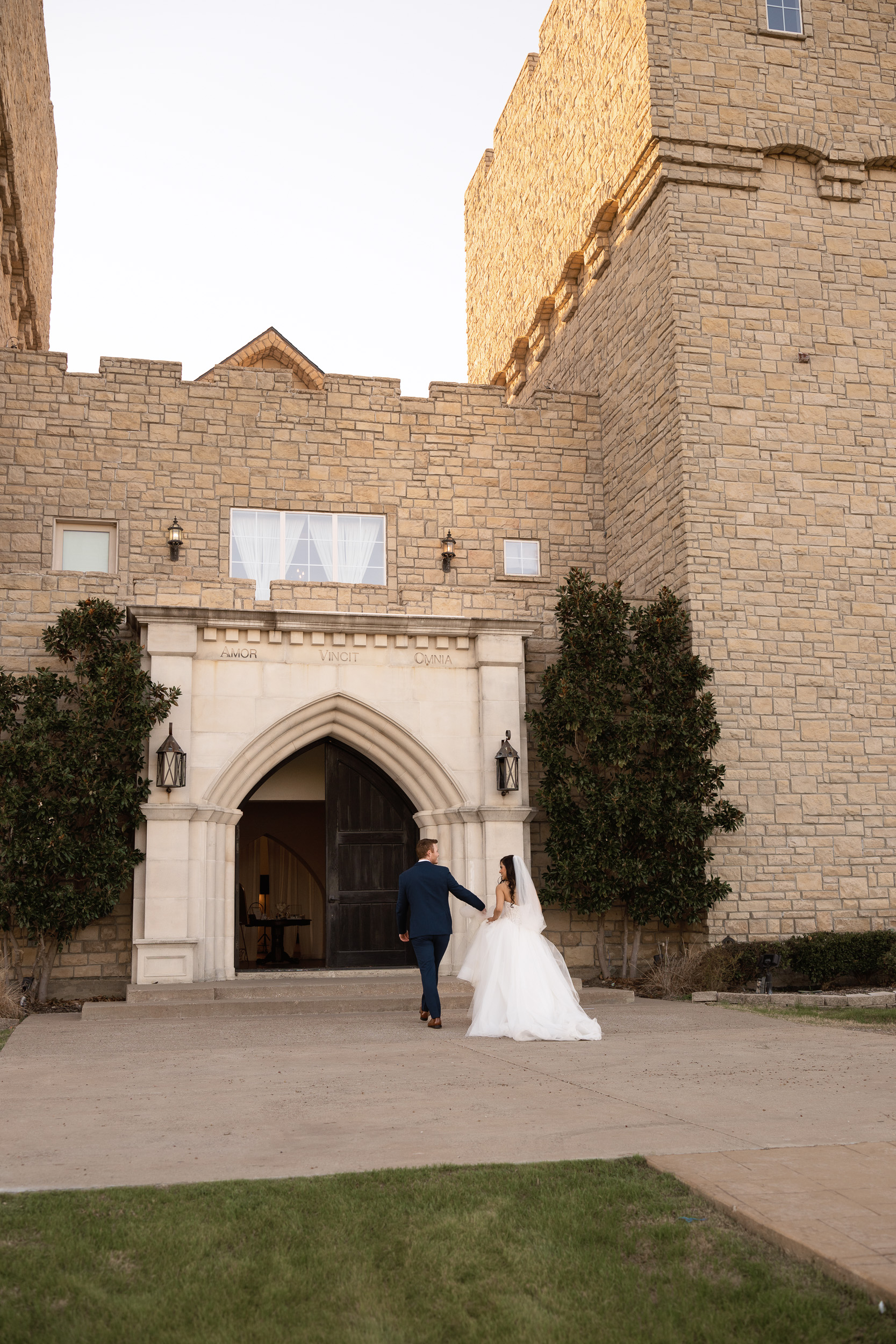 bride and groom walk into the castle wedding venue following their ceremony captured by shelly voss.