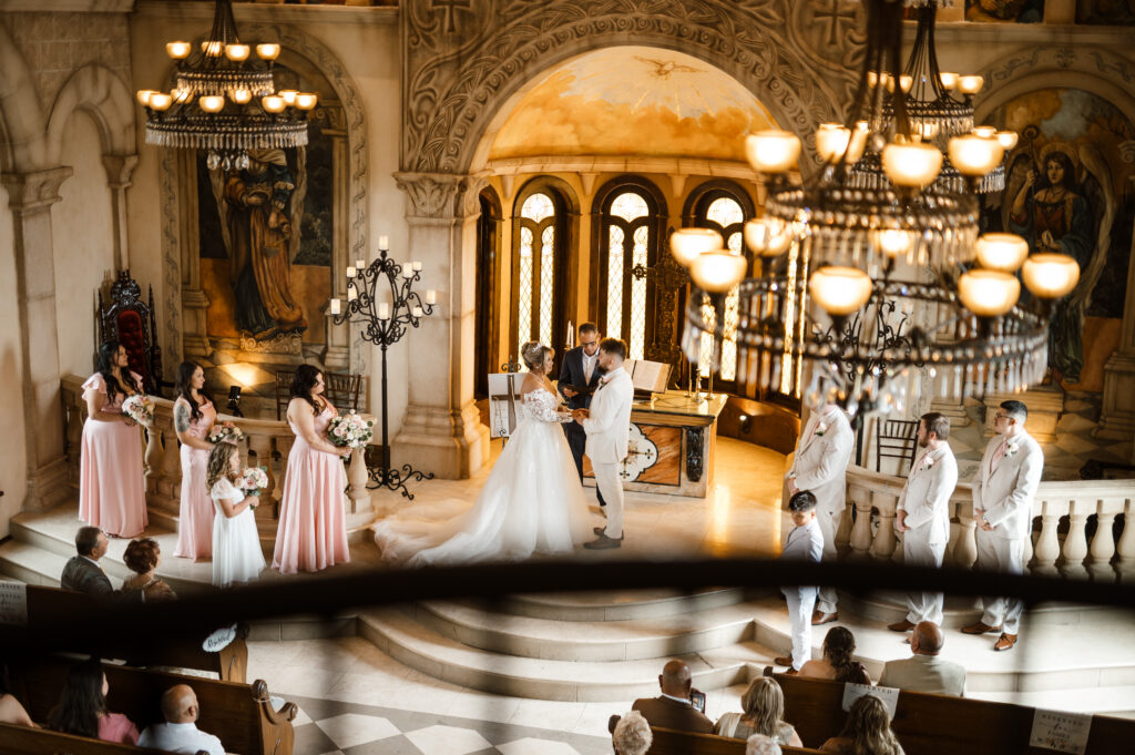 Couple exchanging vows during wedding ceremony at Bella Donna Chapel from the balcony
