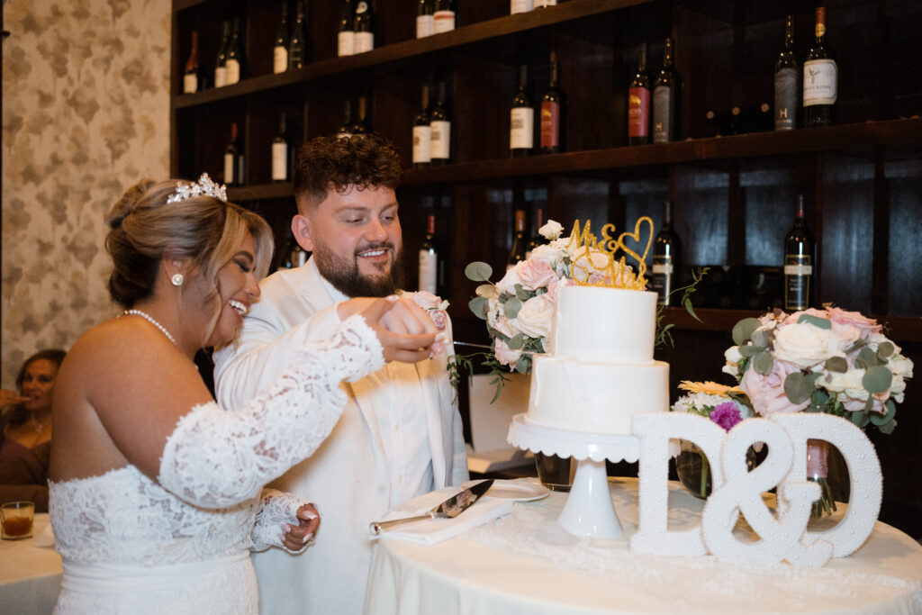 bride and groom cut their wedding cake at Rick's Chophouse after their bella donna chapel wedding in mckinney, texas