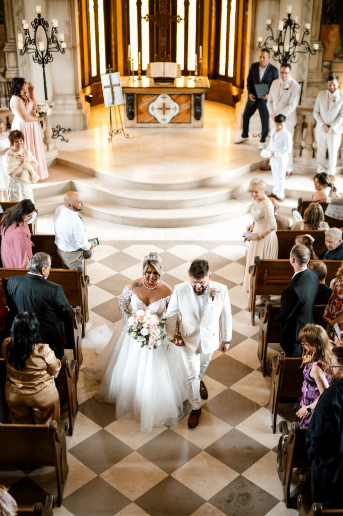 Bride walking down the aisle inside Bella Donna Chapel in Adriatica village