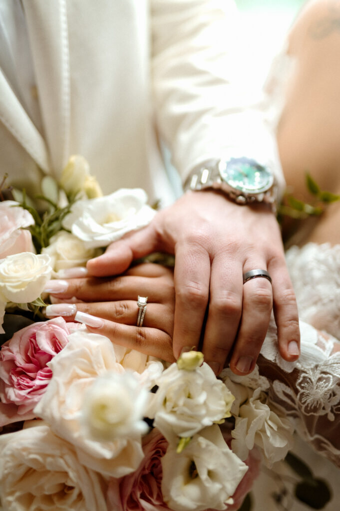 Close-up wedding rings and bridal bouquet photographed outside Bella Donna Chapel