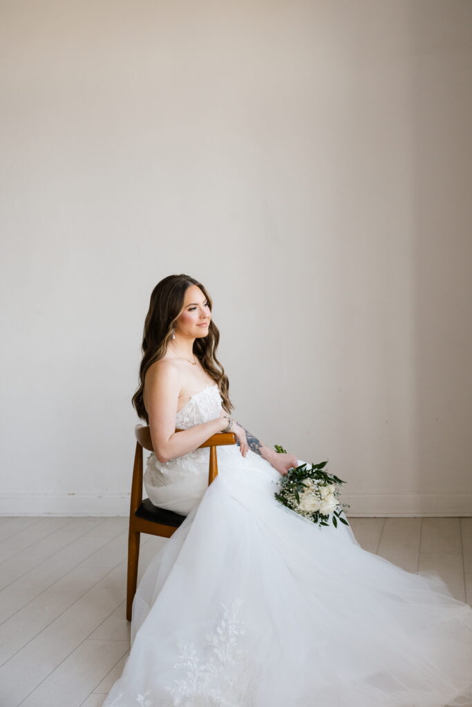bride beams out the window during her bridal session in dallas texas with shelly voss