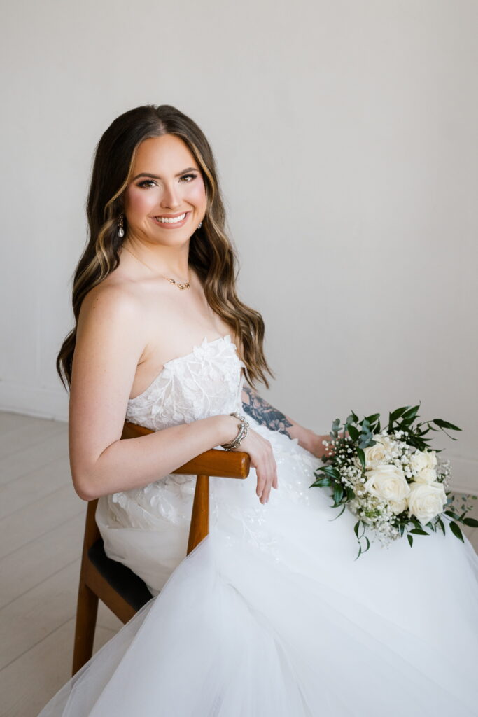 bride leans on chair and smiles during her bridal session with shelly voss photography