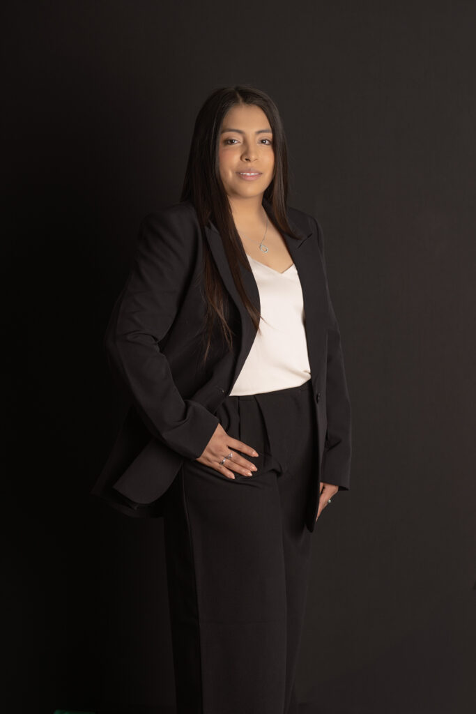 client stands in front of dark backdrop during her studio headshot session
